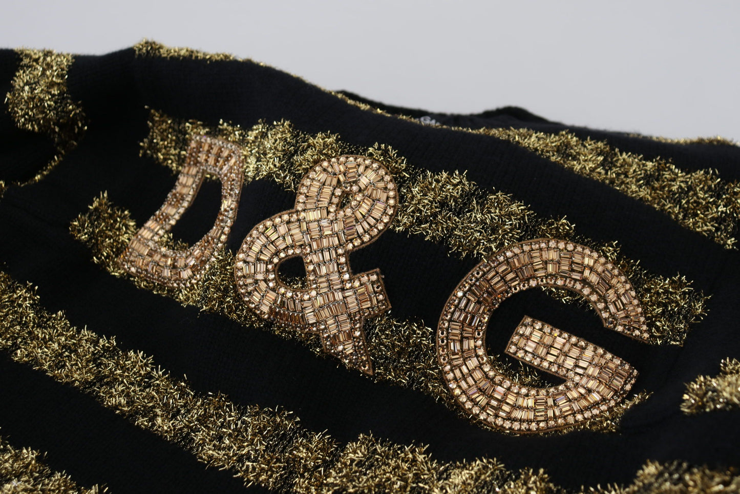Suéter elegante con cristales negros y dorados de Dolce & Gabbana
